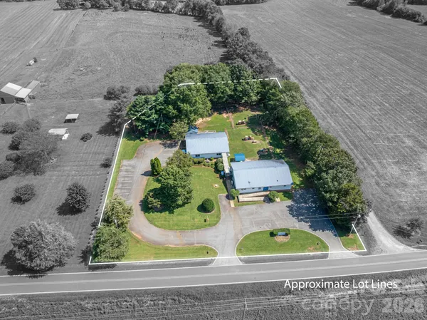 an aerial view of a house with a yard and large trees