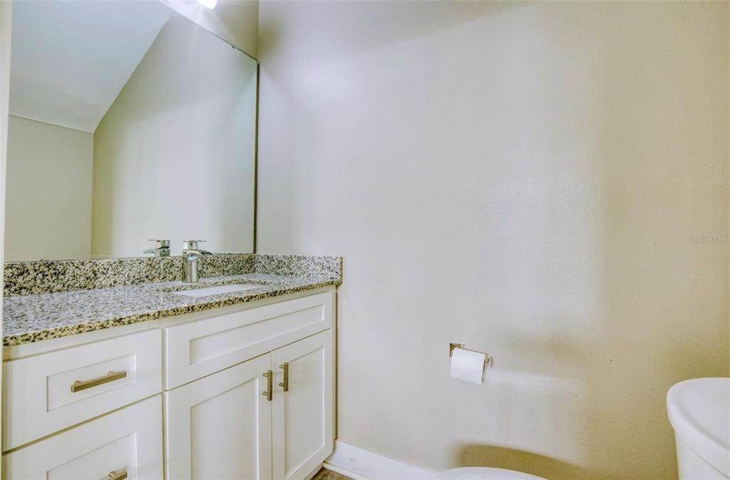 1801 Houston Street Kissimmee, FL 34743 - Photo 16 of 32 a bathroom with a granite countertop sink and a mirror