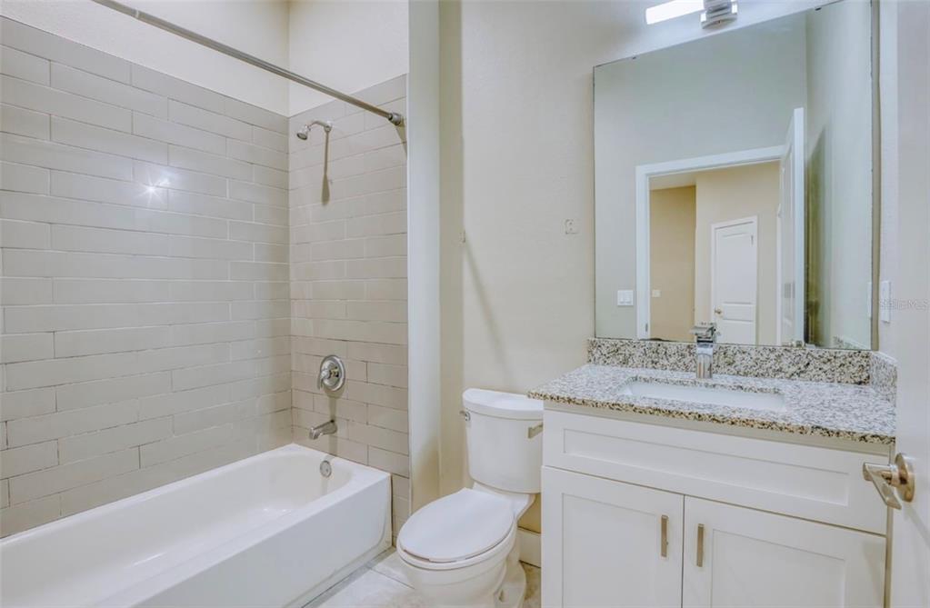 1801 Houston Street Kissimmee, FL 34743 - Photo 27 of 32 a bathroom with a granite countertop toilet a sink and a bathtub