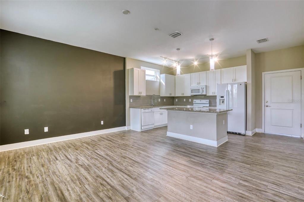 1801 Houston Street Kissimmee, FL 34743 - Photo 5 of 32 a large kitchen with kitchen island a sink stainless steel appliances and cabinets