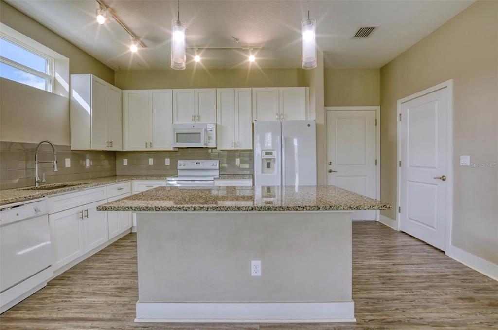 1801 Houston Street Kissimmee, FL 34743 - Photo 10 of 32 a large kitchen with granite countertop a sink a counter top space and cabinets