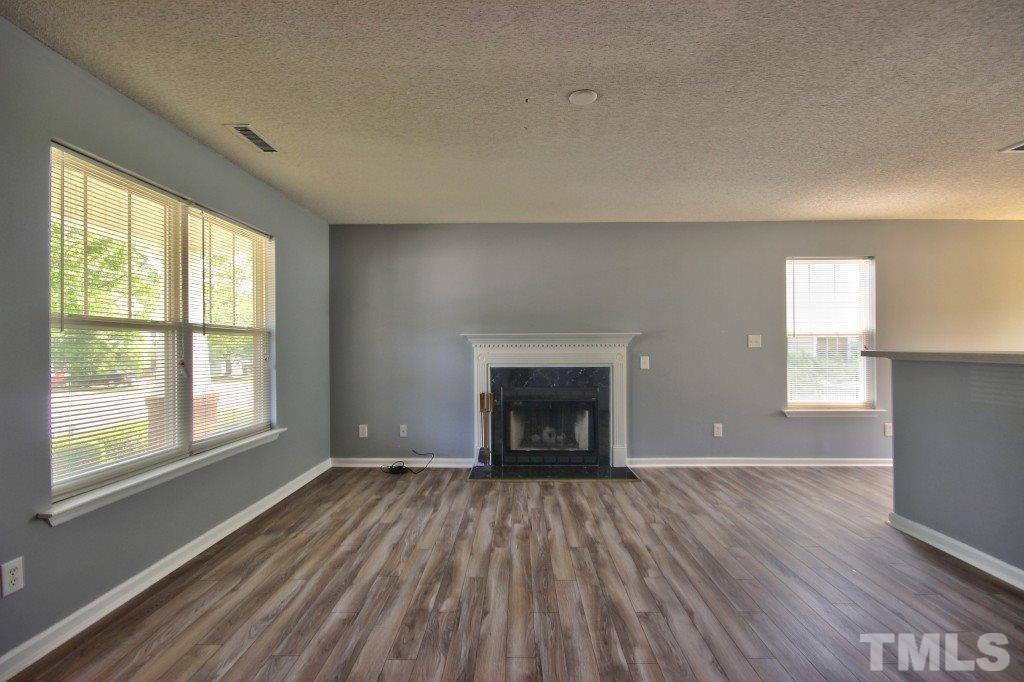 3800 Hopper Street Raleigh, NC 27616 - Photo 4 of 18 wooden floor fireplace and windows in an empty room