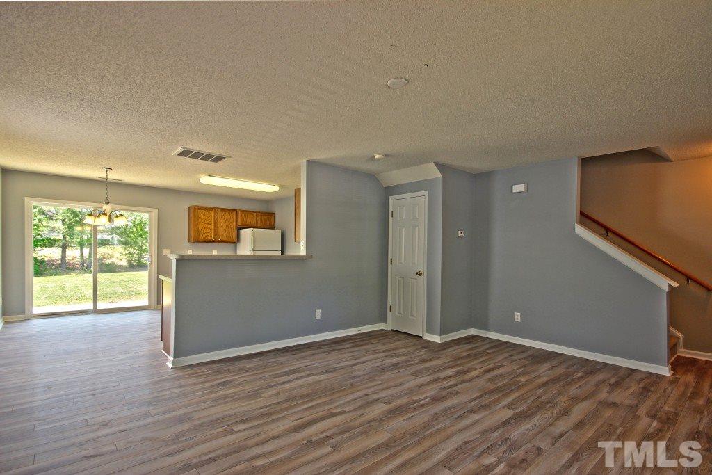3800 Hopper Street Raleigh, NC 27616 - Photo 5 of 18 a view of an empty room with wooden floor and a window