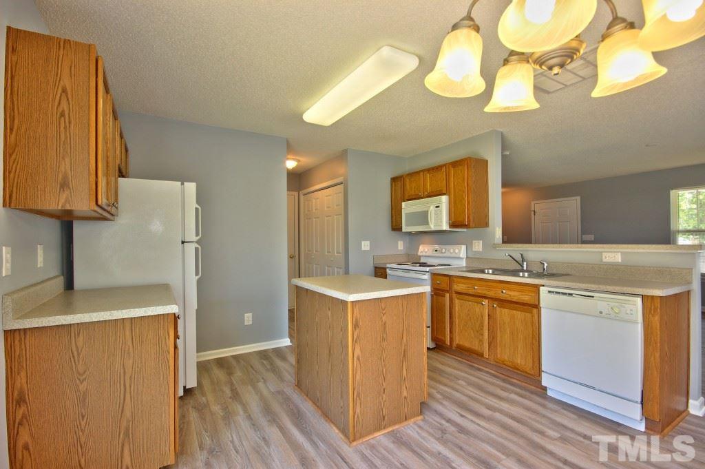 3800 Hopper Street Raleigh, NC 27616 - Photo 6 of 18 a kitchen with stainless steel appliances granite countertop a sink a stove a refrigerator cabinets and wooden floor