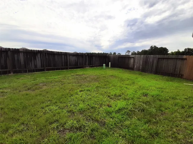 a view of a backyard with wooden fence