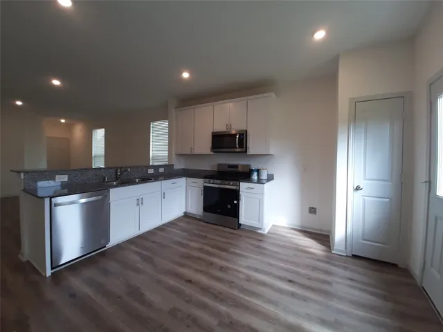 a large kitchen with stainless steel appliances granite countertop a stove a sink and a refrigerator