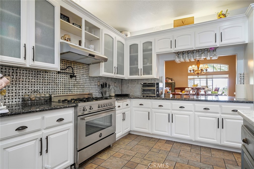 7172 Jargon Road Hesperia, CA 92344 - Photo 19 of 75 a kitchen with granite countertop white cabinets stainless steel appliances a sink and a window