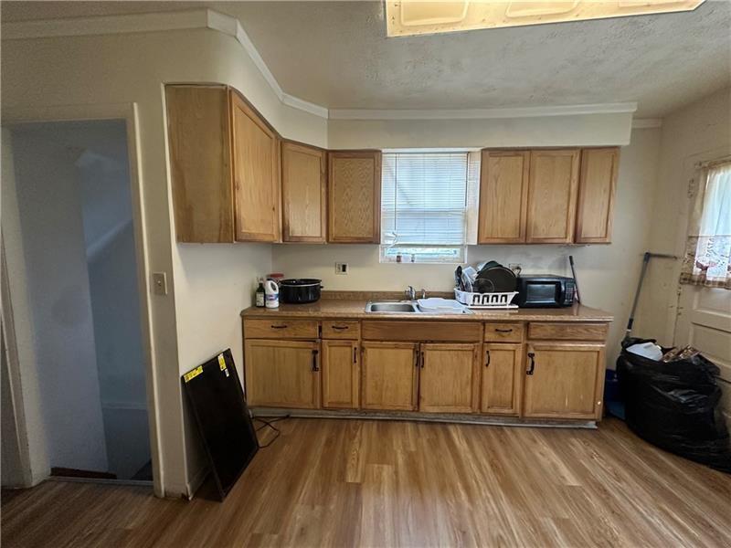 12 Elizabeth Street Pittsburgh, PA 15210 - Photo 17 of 32 a kitchen with granite countertop a sink cabinets and wooden floor