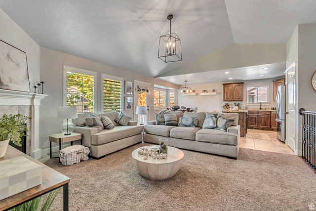 1071 Jamie-Matt Circle Layton, UT 84041 - Photo 17 of 28 Living room with light colored carpet, lofted ceiling, hanging lights, and a fireplace