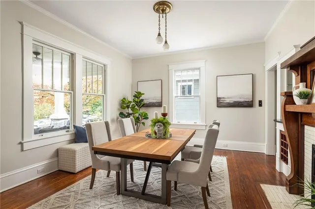 a kitchen with granite countertop a refrigerator a stove a sink and white cabinets with wooden floor