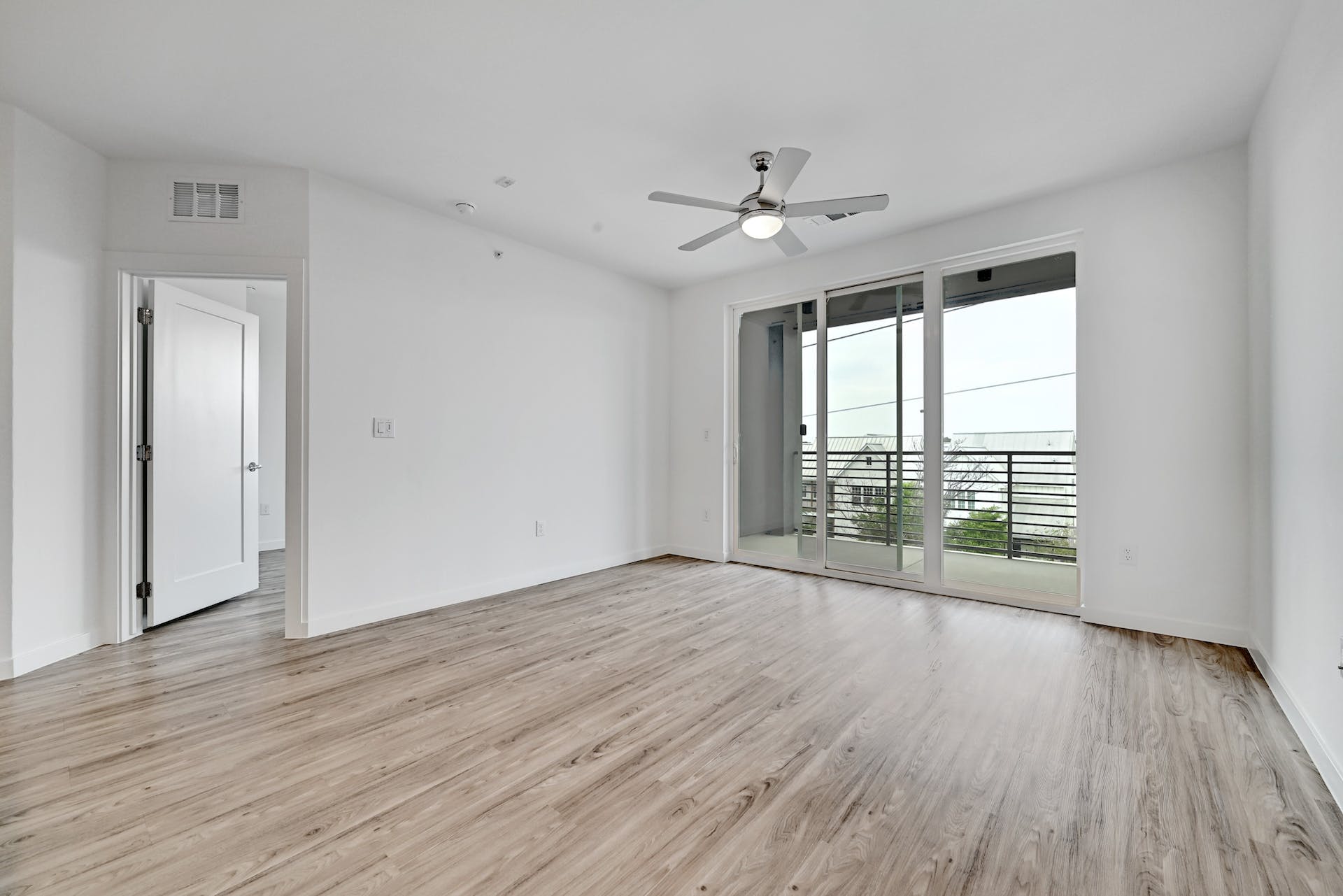 4801 Springdale Road, Unit 1301 Austin, TX 78723 - Photo 16 of 39 A well-lit bedroom with modern flooring offers seamless access to an outdoor balcony.