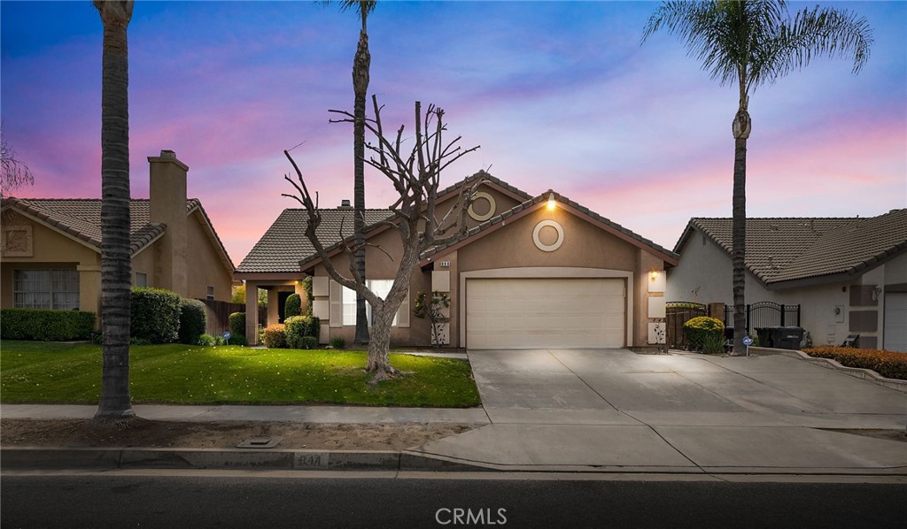 a front view of a house with a garden and yard