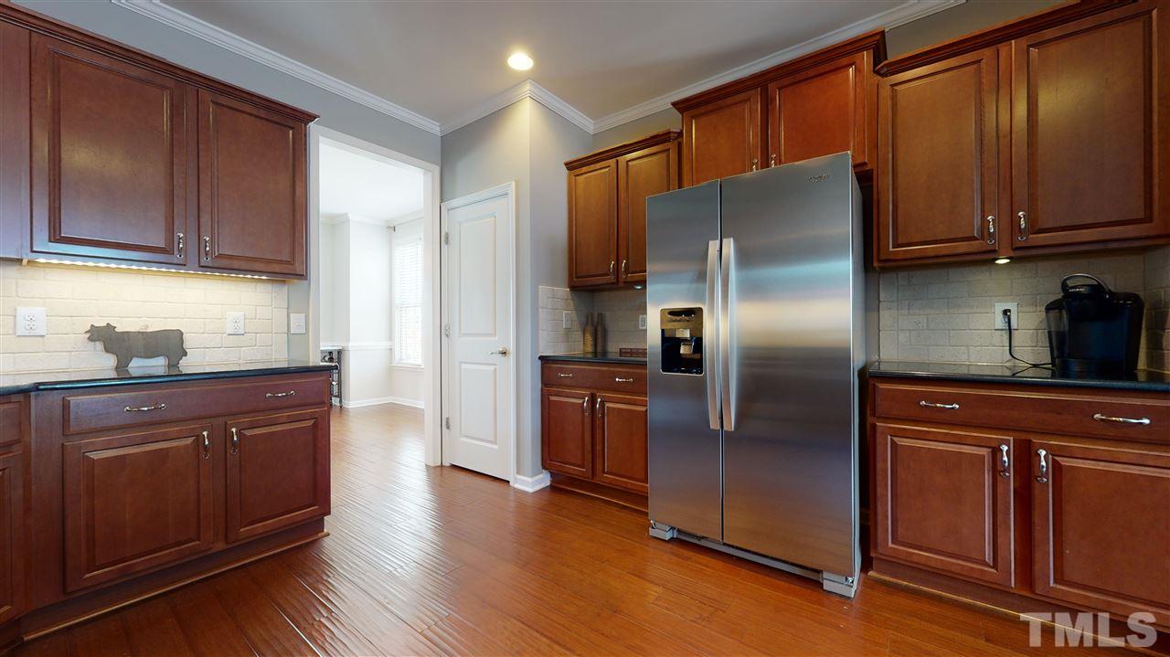 1329 Rembrandt Circle Raleigh, NC 27607 - Photo 10 of 23 a kitchen with stainless steel appliances granite countertop a refrigerator stove top oven and wooden floor