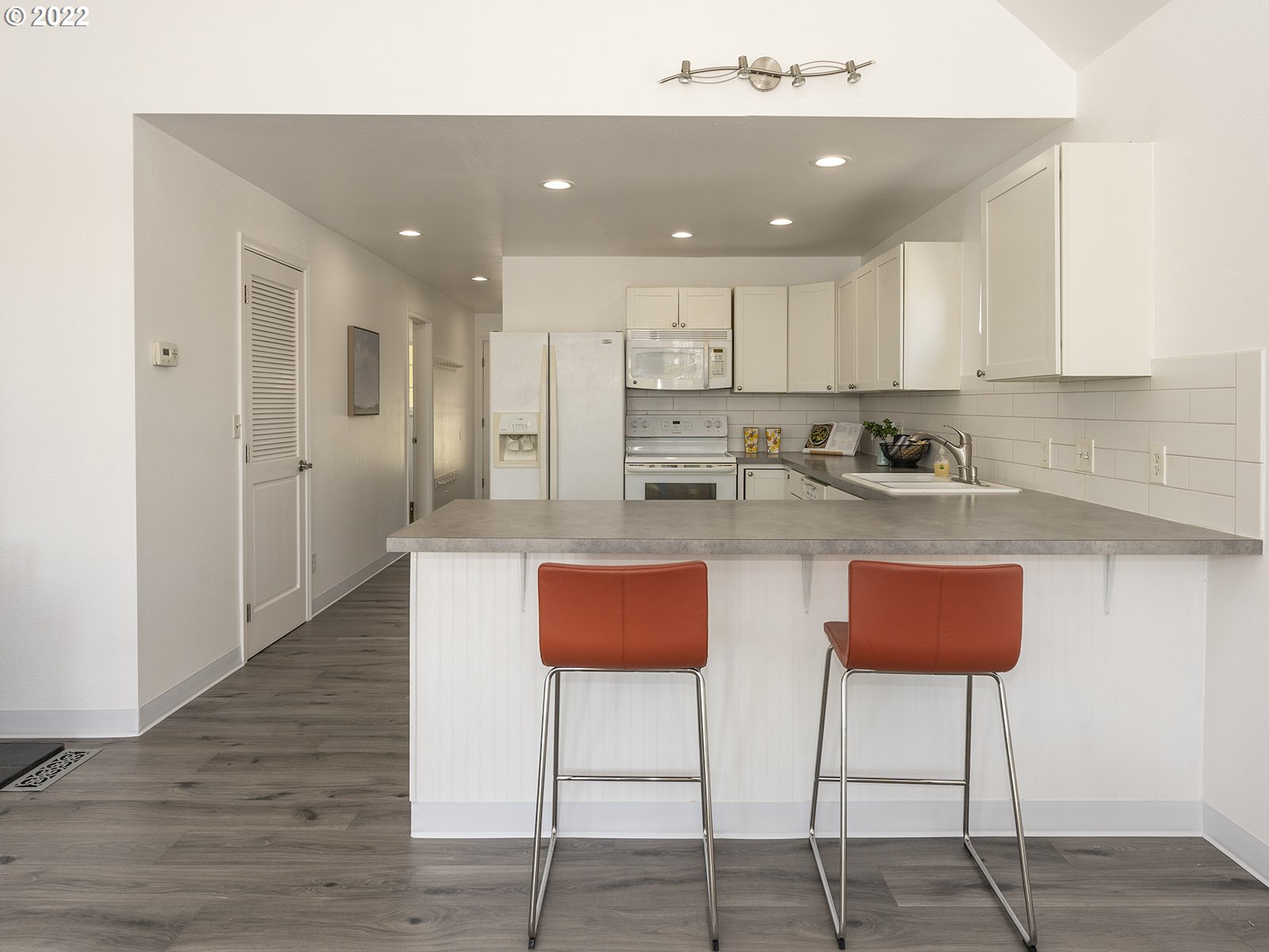 23560 Northwest St Helens Road, Unit N4 Portland, OR 97231 - Photo 16 of 27 a kitchen with stainless steel appliances kitchen island granite countertop a refrigerator and a stove top oven