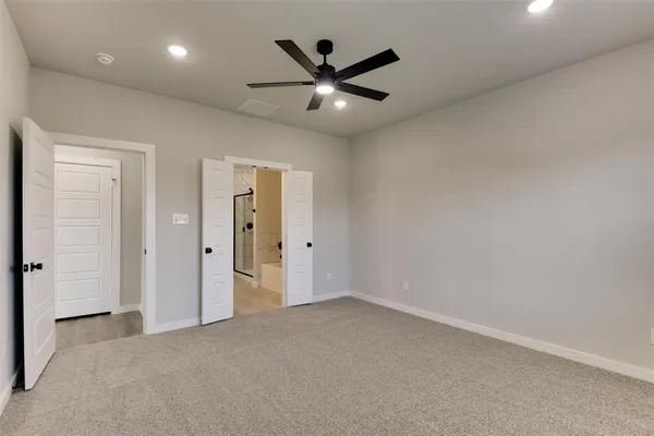 an empty room with closet and ceiling fan