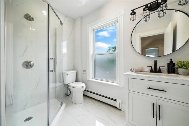 a bathroom with a sink mirror vanity and toilet