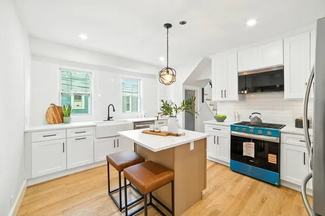 a kitchen with white cabinets and stainless steel appliances