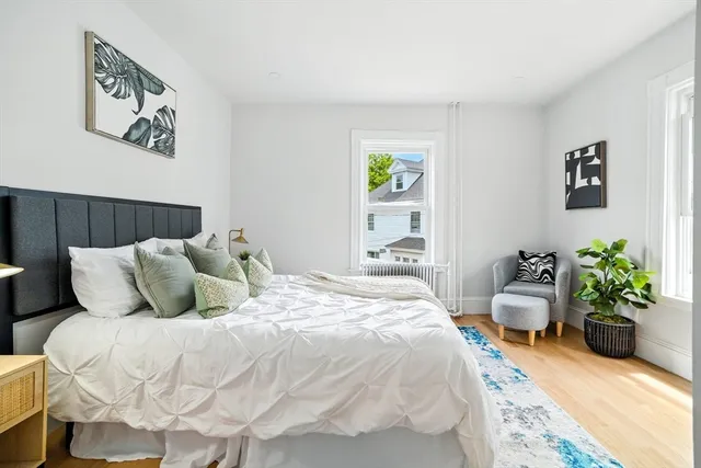 a bedroom with a bed table and a potted plant