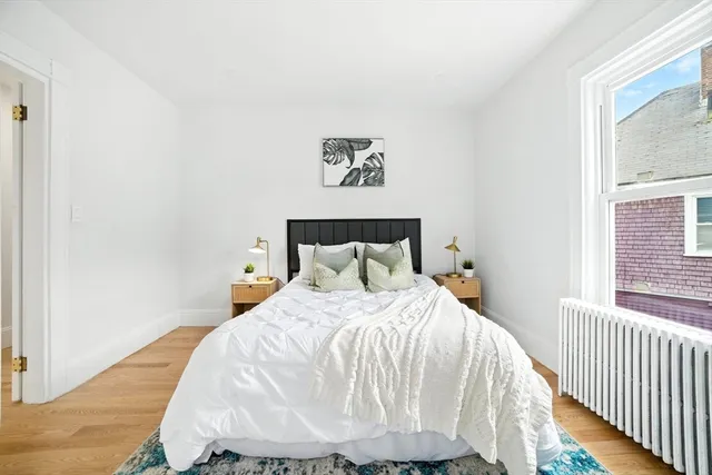 a bed sitting in a bedroom next to a window