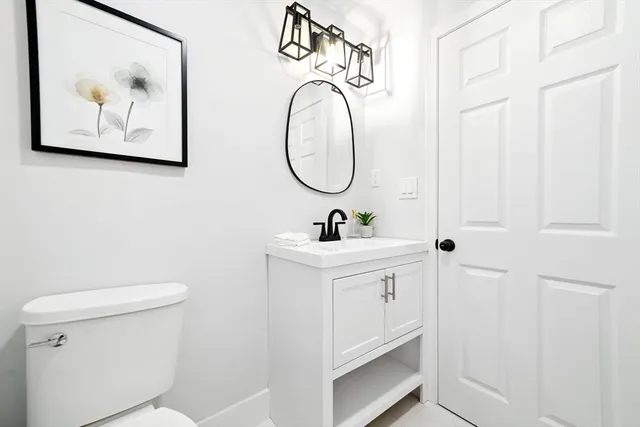 a bathroom with a toilet a sink and a mirror
