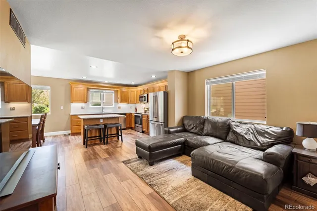a living room with furniture kitchen view and a large window