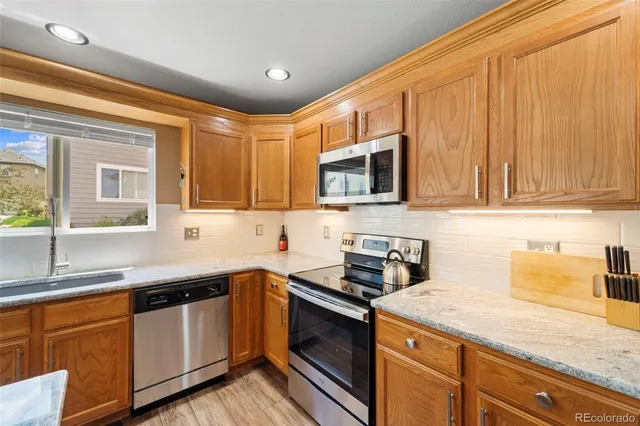 a kitchen with stainless steel appliances granite countertop a sink stove and microwave