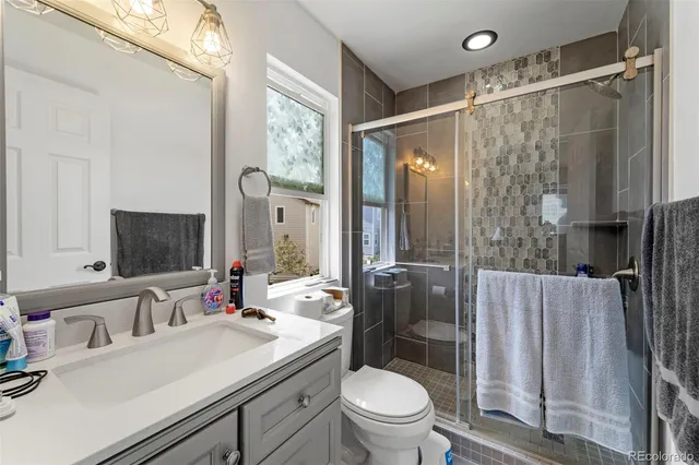 a spacious bathroom with a sink a toilet a mirror and shower