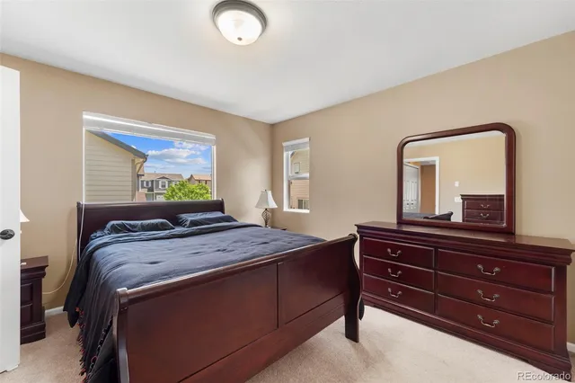 a bedroom with a bed and a mirror on dresser