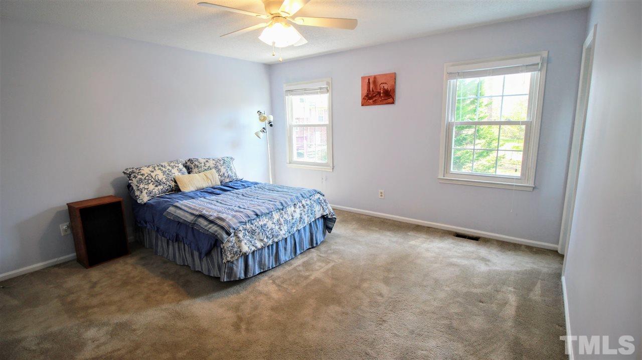 3116 Comstock Road Raleigh, NC 27604 - Photo 8 of 20 a bedroom with a bed lamp and a chandelier