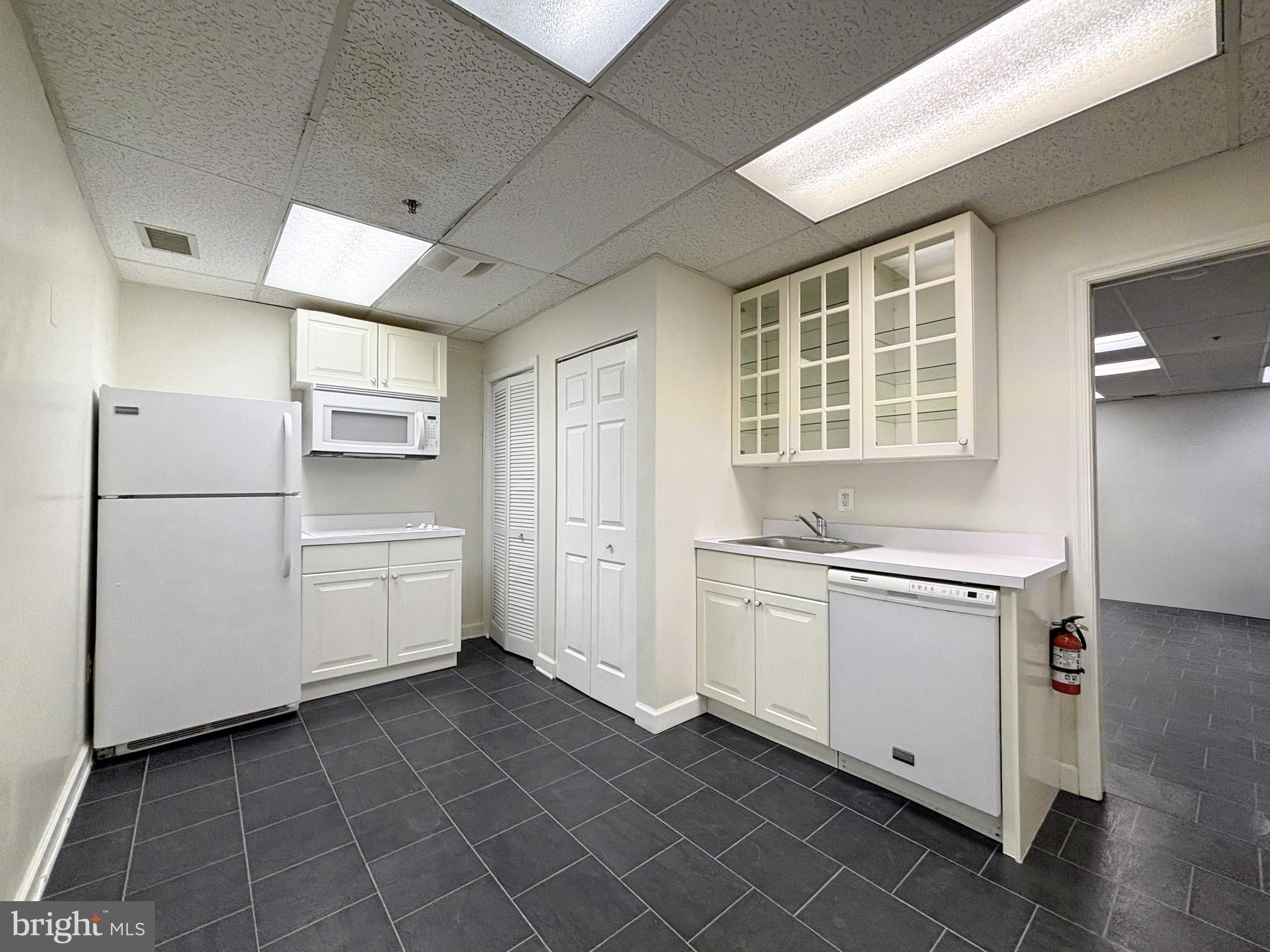 657 A Main Street, Unit A Laurel, MD 20707 - Photo 7 of 25 a kitchen with a stove a refrigerator and white cabinets