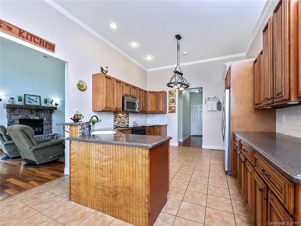 4657 Hickory Grove Road Sharon, SC 29742 - Photo 13 of 32 a kitchen with granite countertop a stove top oven a sink dishwasher a dining table and chairs with wooden floor