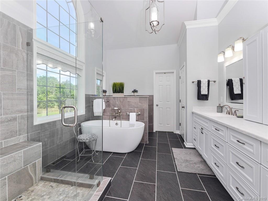 4657 Hickory Grove Road Sharon, SC 29742 - Photo 16 of 32 a spacious bathroom with a double vanity sink a mirror a bathtub and next to a window