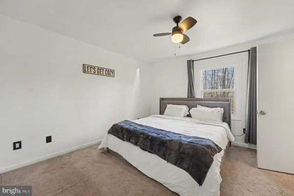a bedroom with a large bed a flat tv screen and a book shelf