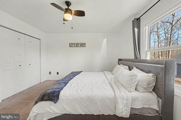 a view of a bedroom with baby bed and lounge chair