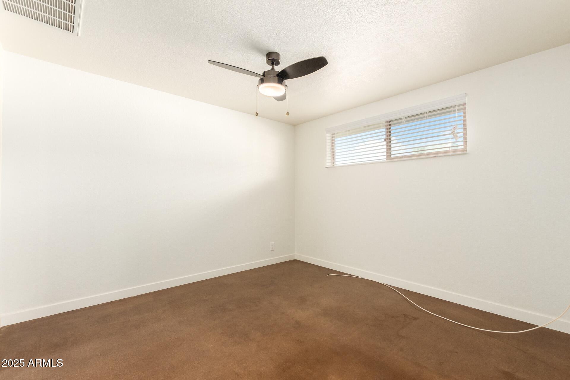 616 South Bellview, Unit C Mesa, AZ 85204 - Photo 13 of 19 an empty room with a ceiling fan and window