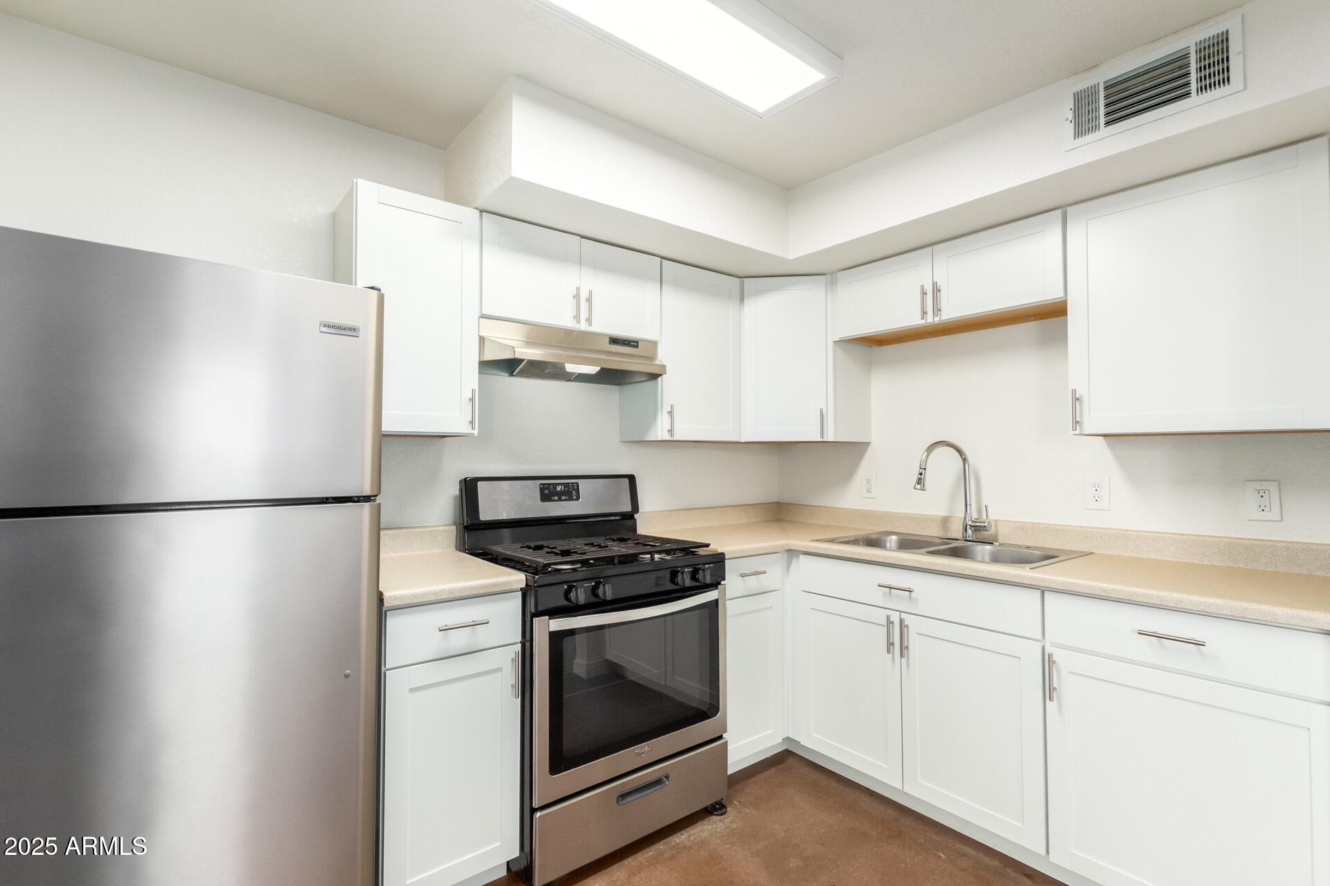 616 South Bellview, Unit C Mesa, AZ 85204 - Photo 2 of 19 a kitchen with a white cabinets and white appliances