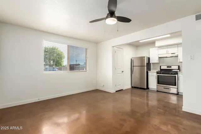 a view of a kitchen with refrigerator and wooden floor