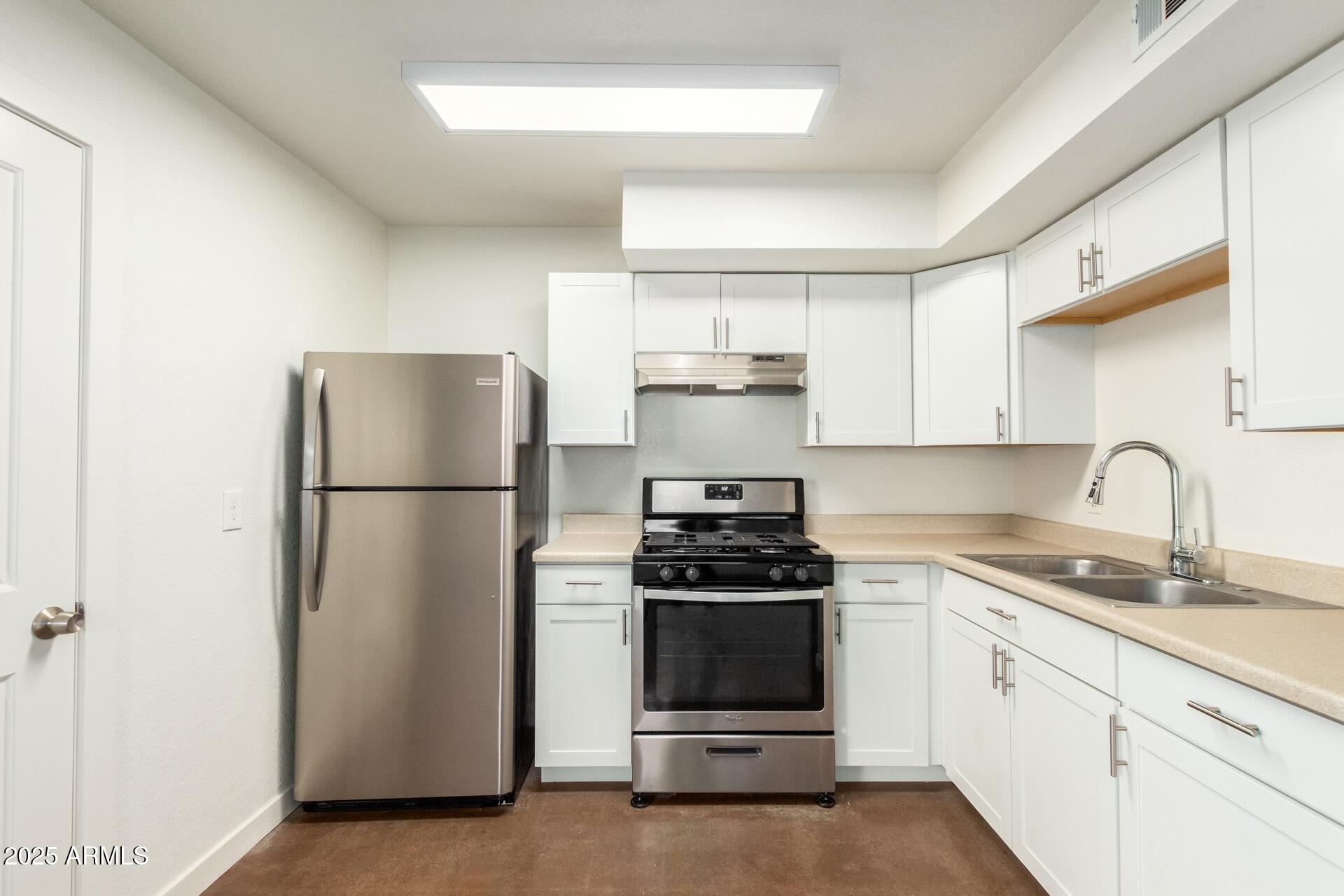 616 South Bellview, Unit C Mesa, AZ 85204 - Photo 7 of 19 a kitchen with a refrigerator sink and white cabinets