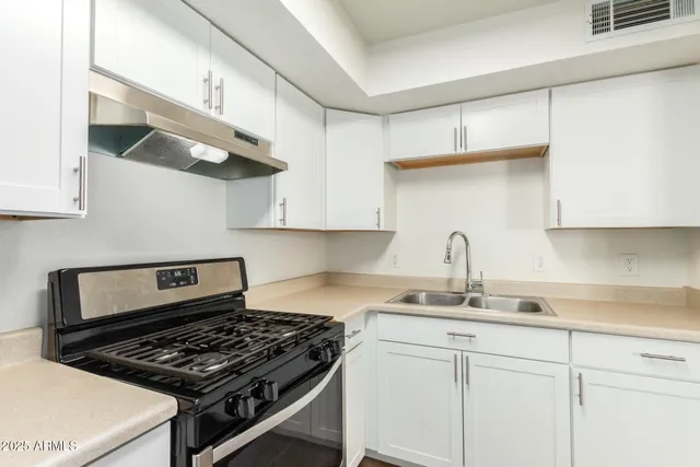a kitchen with white cabinets and appliances