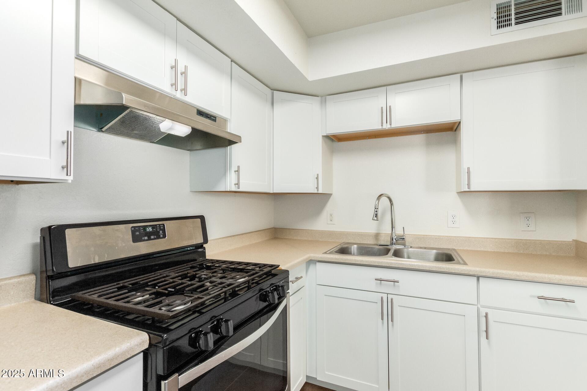 616 South Bellview, Unit C Mesa, AZ 85204 - Photo 10 of 19 a kitchen with white cabinets and appliances