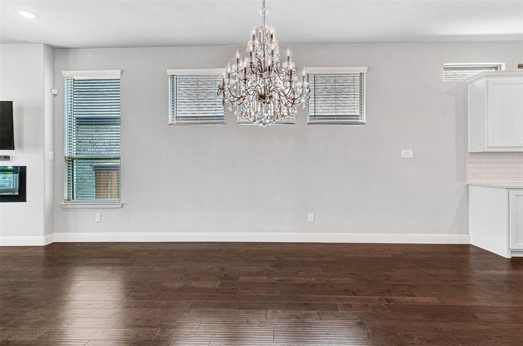 468 Caitlyn Way Fairview, TX 75069 - Photo 11 of 35 Unfurnished dining area with dark wood-style flooring and a chandelier