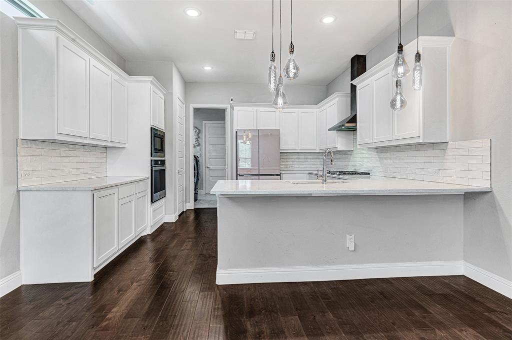 468 Caitlyn Way Fairview, TX 75069 - Photo 13 of 35 Kitchen with tasteful backsplash, white cabinetry, a peninsula, and dark wood finished floors