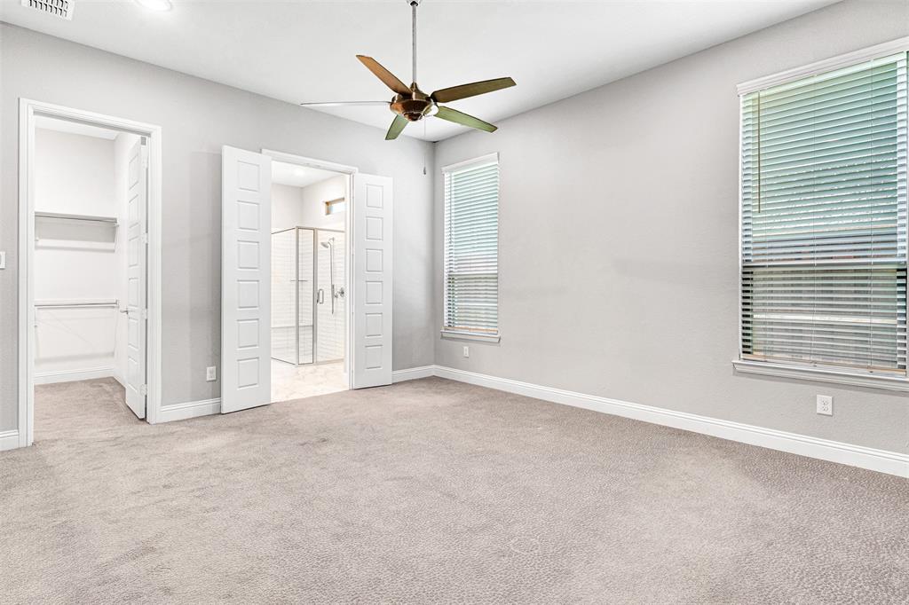 468 Caitlyn Way Fairview, TX 75069 - Photo 18 of 35 Unfurnished bedroom featuring a walk in closet, light carpet, and a ceiling fan