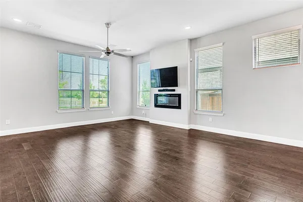 a view of a livingroom with a flat screen tv wooden floor and a window