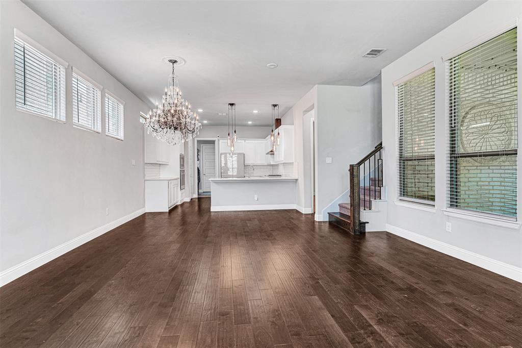 468 Caitlyn Way Fairview, TX 75069 - Photo 10 of 35 Unfurnished living room featuring suspended lighting and dark wood-type flooring