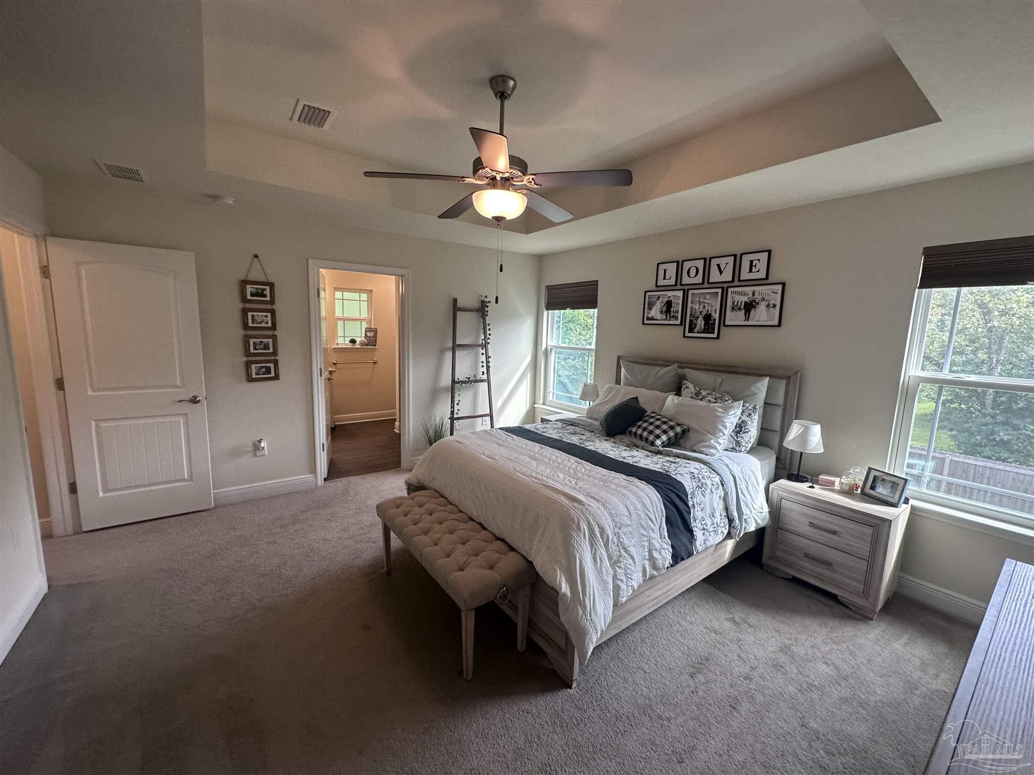 5217 Saufley Field Road Pensacola, FL 32526 - Photo 22 of 26 a spacious bedroom with a bed and a chandelier