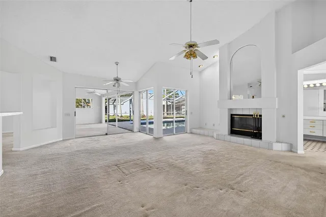 a view of an empty room with a fireplace and a chandelier