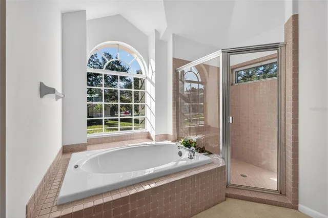 a bathroom with a tub a window and a shower