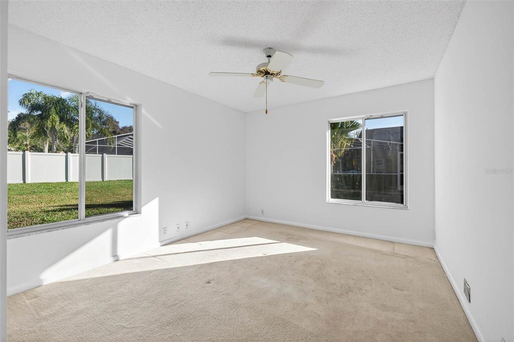 1819 Tree Swallow Way Palm Harbor, FL 34683 - Photo 21 of 37 an empty room with a fireplace and windows