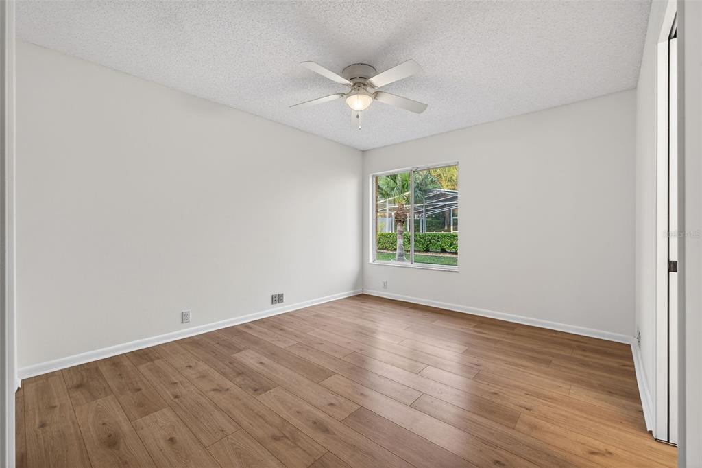 1819 Tree Swallow Way Palm Harbor, FL 34683 - Photo 24 of 39 an empty room with wooden floor fan and windows